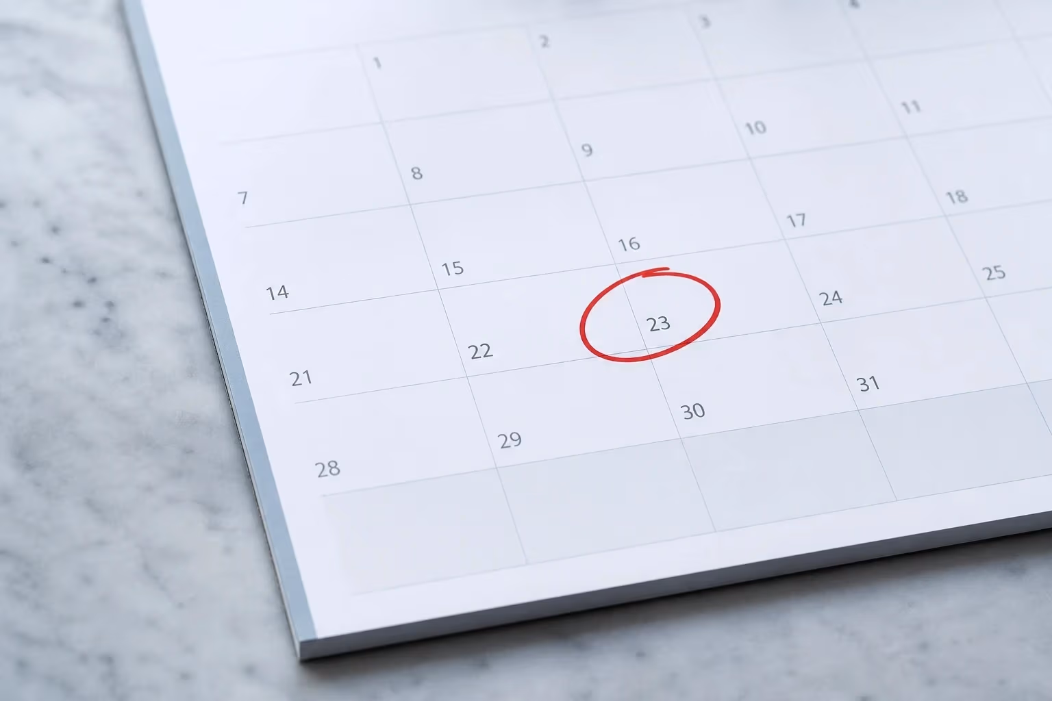 "Griglia di calendario freddo con un cerchio rosso a mano su una cella: il giorno chiave del piano"